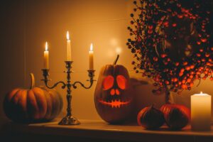 Beautiful smiling orange carved pumpkin jack o lantern for Halloween holiday at night home interior